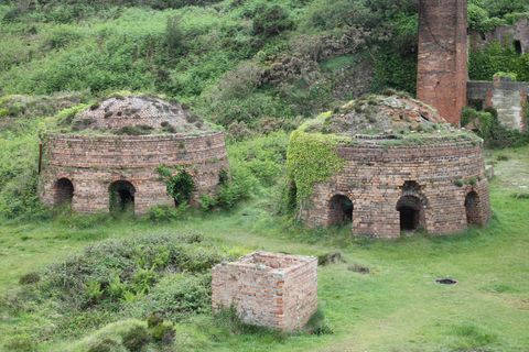Two curious round brick structures emerge from the grass, each is topped with a dome and set with regularly spaced tunnel entrances. Ferns grow at their edges, creeping plants coat their walls and scrubby grasses are beginning to coat their rooves.