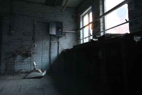 A workshop, a sink lies upside down on the floor beside the stop on the wall it used to occupy. Above the workbench, pale morning light streams in through the windows, illuminating everything a soft blue.